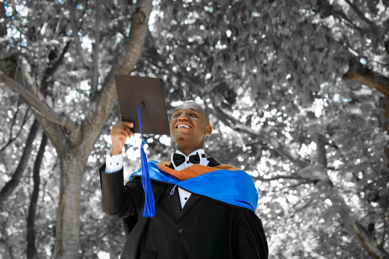 African American graduate tossing his graduation cap into the air